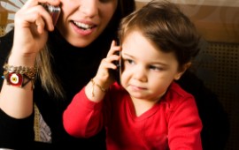 Mom with child, working on computer and on cell.