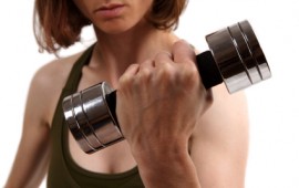 Lady strength training with dumbell.