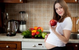 Pregnant lady with fresh fruits and vegetables.